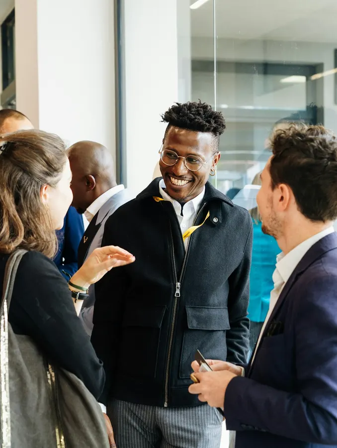 Des professionnels échangent en souriant lors d'un afterwork de networking