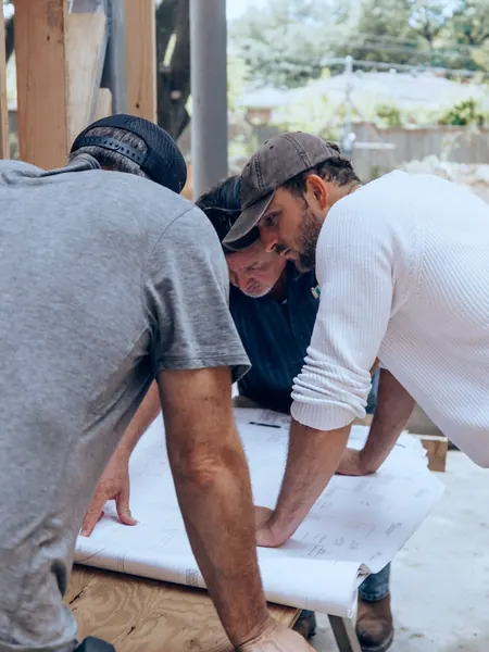 Une équipe de chantier penchée sur des plans étalés