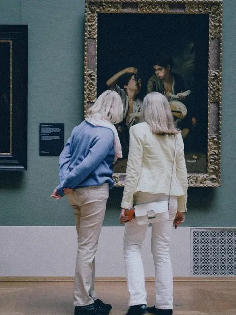 Deux visiteuses observent un tableau dans un musée